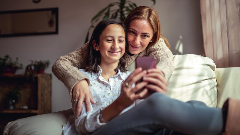 mom and daughter looking at the phone together