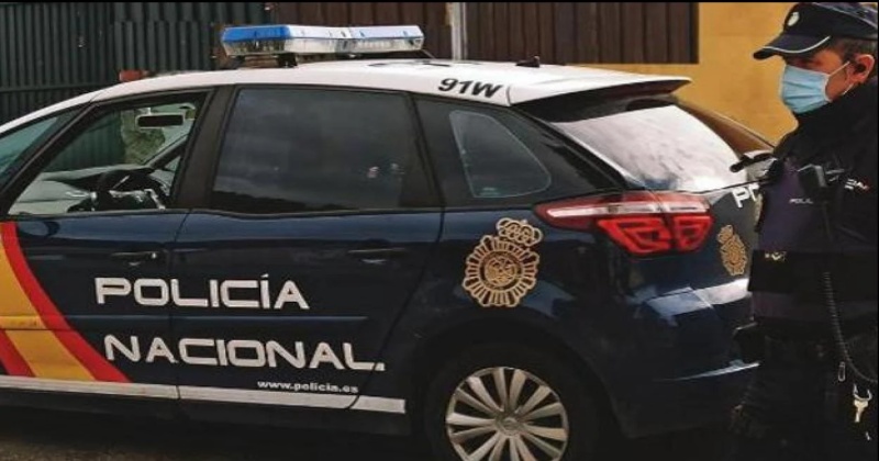 A Police Officer in Spain Stands Next to His Vehicle